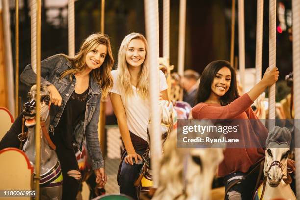 teenage women friend group enjoying state fair - carousel horse stock pictures, royalty-free photos & images