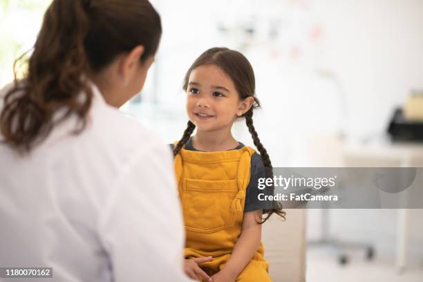 chica recibiendo chequeo con la foto de stock del doctor - pediatra fotografías e imágenes de stock