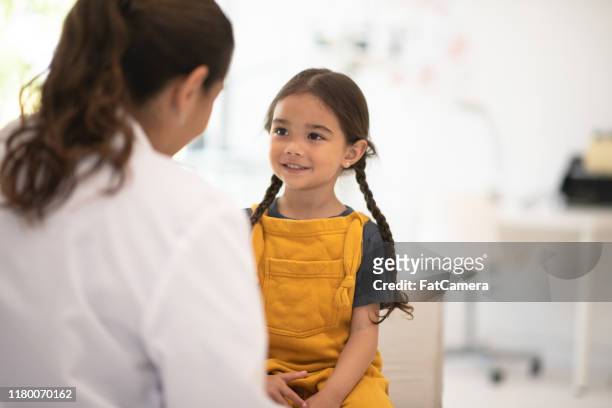 girl receiving check up with the doctor stock photo - child patient stock pictures, royalty-free photos & images