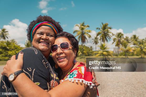 women hugging on the beach - coconut beach woman stock pictures, royalty-free photos & images