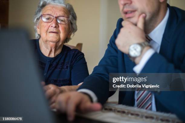 old woman looking art business man's laptop - lawyer client stock pictures, royalty-free photos & images