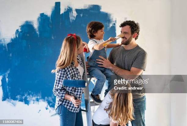familie mit spaß beim malen ihres hauses - youth foundation stock-fotos und bilder
