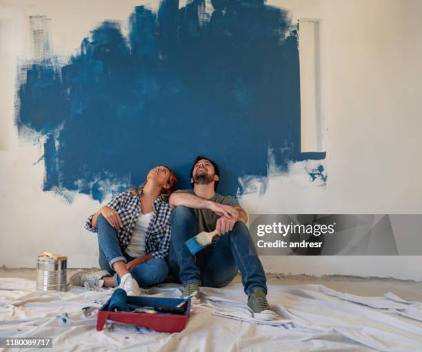 thoughtful couple painting their house - dreaming stock pictures, royalty-free photos & images