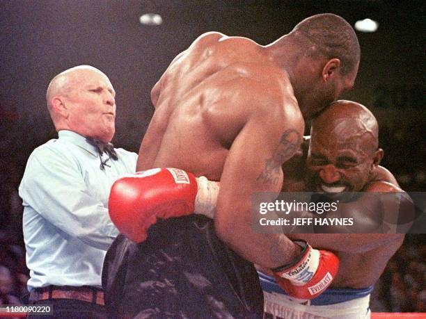 Referee Lane Mills steps in as Evander Holyfield reacts after Mike Tyson bit his ear in the third round of their WBA heavyweight championship fight...