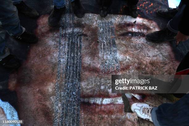 Libyan protesters step on a poster of leader Moamer Kadhafi in the eastern Libyan city of Benghazi on February 28, 2011 as world powers ramped up the...