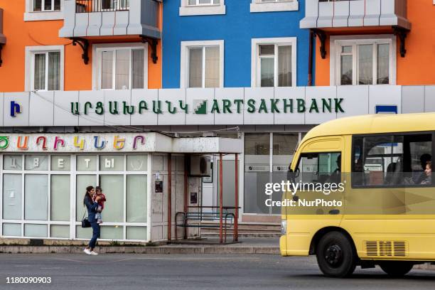 Woman stands with har baby on a street of Stepanakert, a capital of unrecognised Republic of Artsakh on October 9, 2019. The Republic is a subject of...