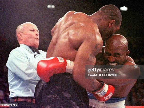 Referee Lane Mills steps in as Evander Holyfield reacts after Mike Tyson bit his ear in the third round of their WBA heavyweight championship fight...