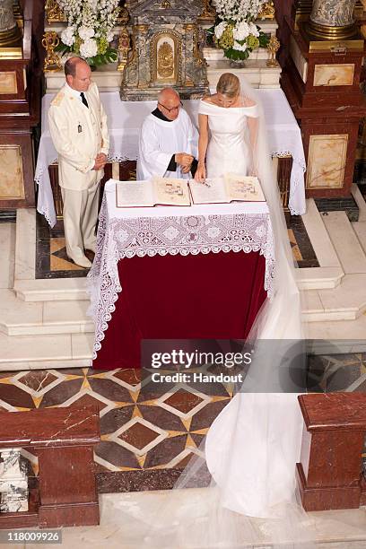 In this handout image provided by the Palais Princier, Princess Charlene of Monaco and Prince Albert II of Monaco stand at the altar during the...