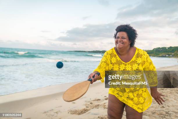 mulher do afro que joga o tênis da praia - mulher gorda - fotografias e filmes do acervo