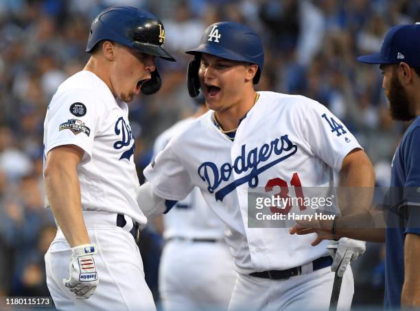 Kike Hernandez of the Los Angeles Dodgers celebrates his solo home run with teammate Joc Pederson to take a 3-0 lead in the second inning of game...