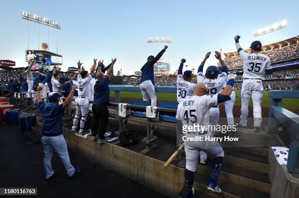 The Los Angeles Dodgers dug out celebrate after Max Muncy hit a two run home run in the first inning of game five of the National League Division...