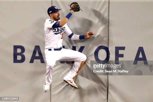 Cody Bellinger of the Los Angeles Dodgers makes a catch on the wall on a hit by Howie Kendrick of the Washington Nationals for an out in the fourth...