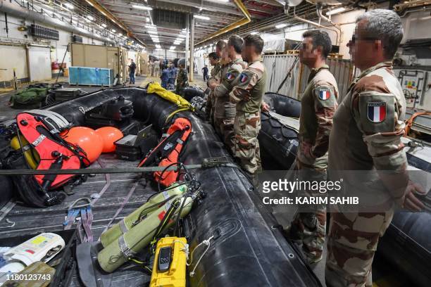 French divers aboard Britain's RFA Cardigan Bay landing ship in the Gulf waters off Bahrain stand next to a rigid-hull inflatable boat during the...