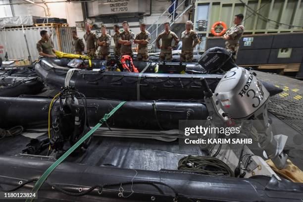 French divers aboard Britain's RFA Cardigan Bay landing ship in the Gulf waters off Bahrain stand next to a rigid-hull inflatable boat during the...