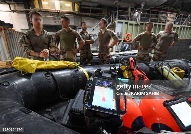 French divers aboard Britain's RFA Cardigan Bay landing ship in the Gulf waters off Bahrain stand next to a rigid-hull inflatable boat during the...