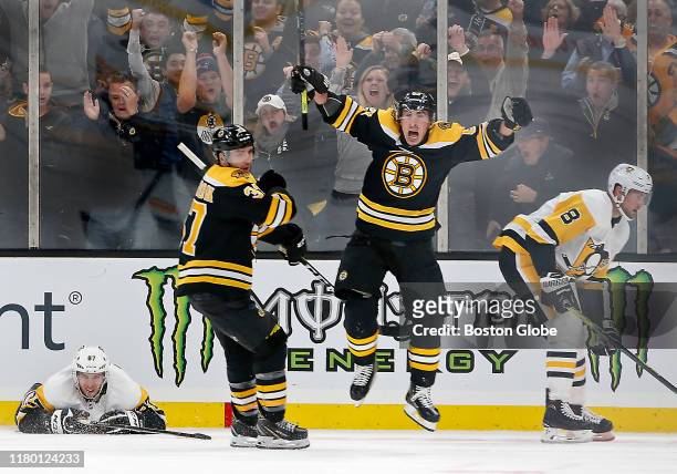 Boston Bruins' Brad Marchand celebrates his game-winning goal with teammate Patrice Bergeron in front of Pittsburgh Penguins' Sidney Crosby and Brian...