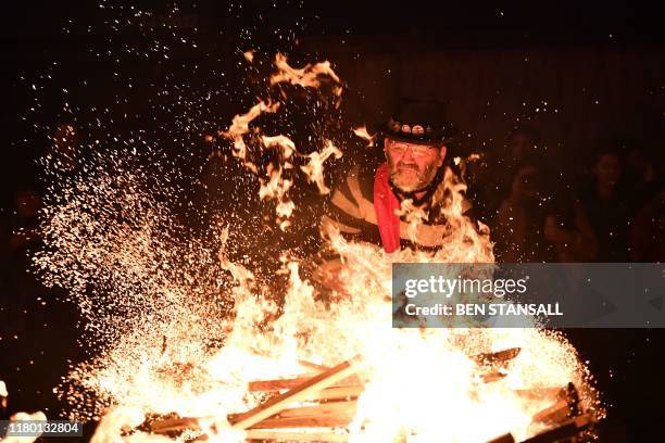 Revellers' torches are thrown into the fire after being paraded through the streets of Lewes in East Sussex, southern England, on November 5 during...