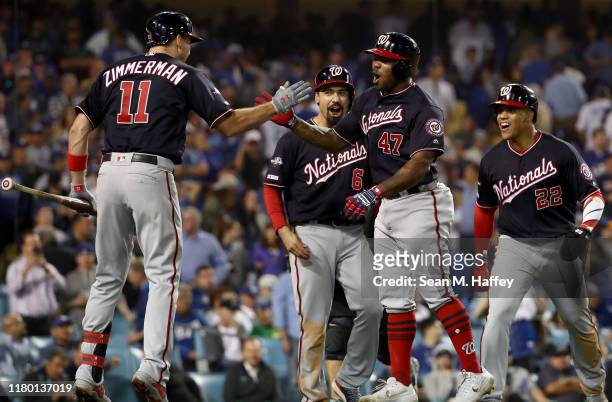 Howie Kendrick of the Washington Nationals celebrates after hitting a grand slam with teammates Juan Soto, Ryan Zimmerman and Anthony Rendon in the...