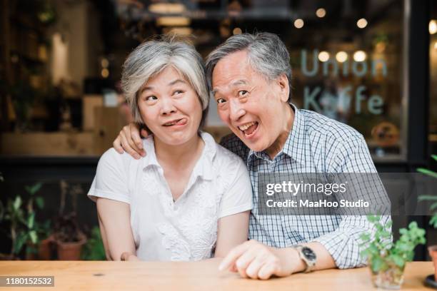 portrait of senior couple sitting together - couple de vieux drole photos et images de collection