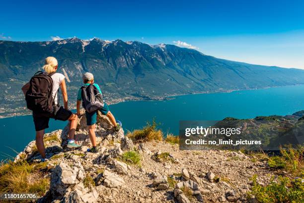 matriz e filho que olham para baixo ao lago garda em italy - lago di garda - fotografias e filmes do acervo