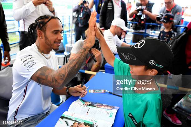 Lewis Hamilton of Great Britain and Mercedes GP greets fans at the autograph signing session during previews ahead of the F1 Grand Prix of Japan at...