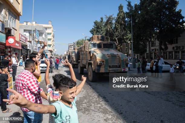 Turkish armoured vehicles escort members of the Turkish-backed Free Syrian Army, a militant group active in parts of northwest Syria, as they enter...