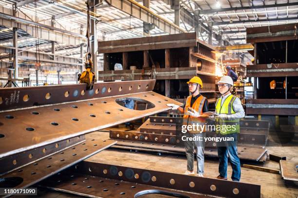 twee metaalarbeiders die een kraan in een staalfabriek bedienen - metal industry stockfoto's en -beelden