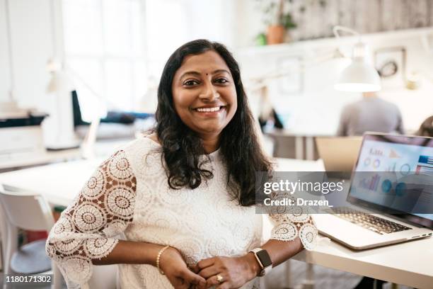 indische geschäftsfrau arbeitet im büro auf laptop, umgang mit charts und finanzen - employees diversity stock-fotos und bilder