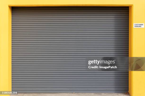 clean vehicle roller door set in bright yellow surround - wallpaper roll stockfoto's en -beelden