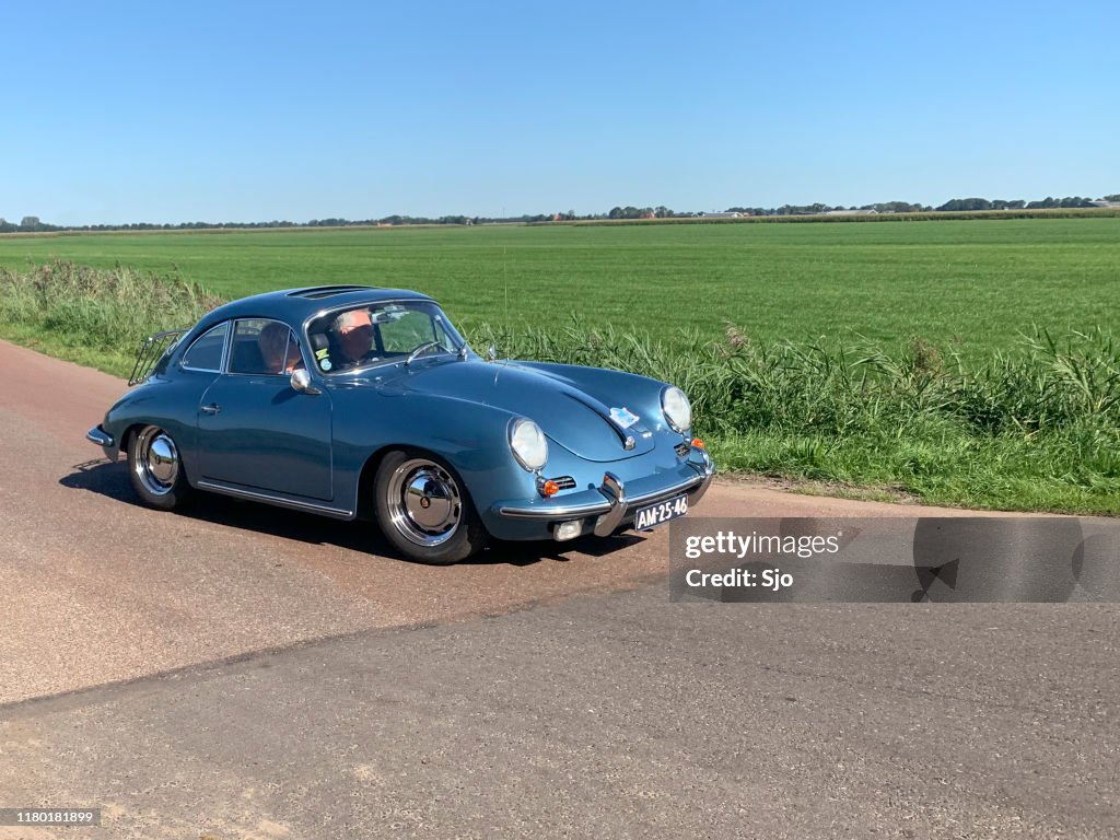 Porsche 356 classic German sports car driving on a country road