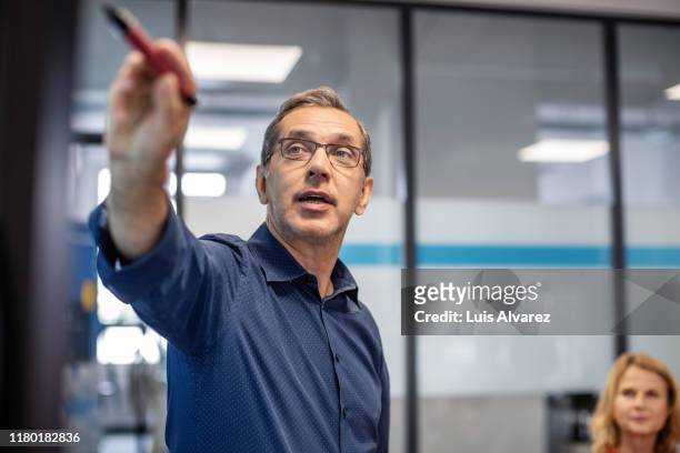 businessman giving presentation in office - explaining stock pictures, royalty-free photos & images