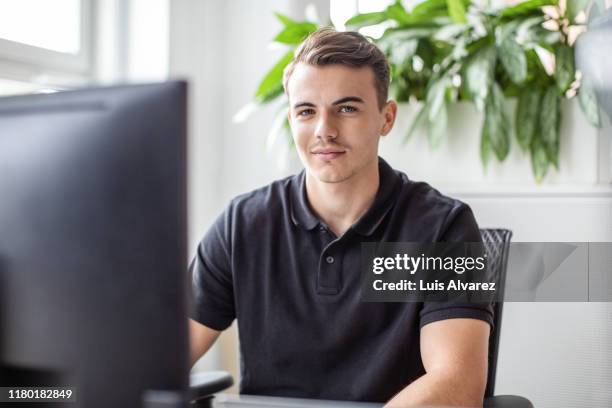 portrait of businessman using computer in office - lässig schicker stil stock-fotos und bilder