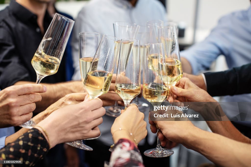 Business people toasting champagne flutes in office