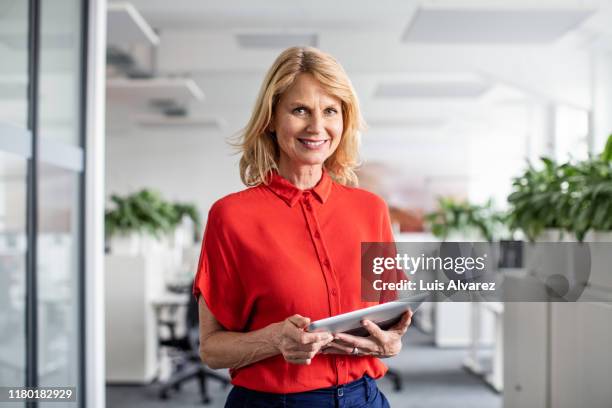 confident businesswoman holding digital tablet in office - portrait blurred background stock pictures, royalty-free photos & images