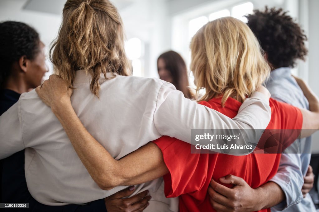 Creative business professionals huddling in office
