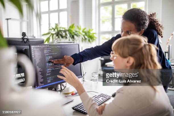 businesswomen discussing coding on computer - ontwikkeling stockfoto's en -beelden