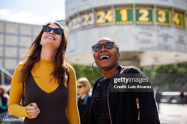 cheerful female friends in city during vacation - berlin diversity alexanderplatz stockfoto's en -beelden