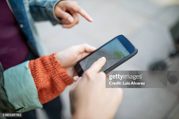 cropped hands of woman pointing at map on smart phone - berlin map stock pictures, royalty-free photos & images