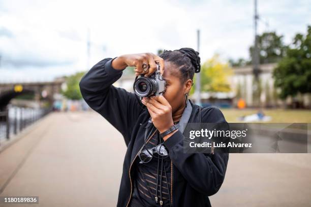 woman photographing through camera on street during vacation - appareil photo numérique photos et images de collection