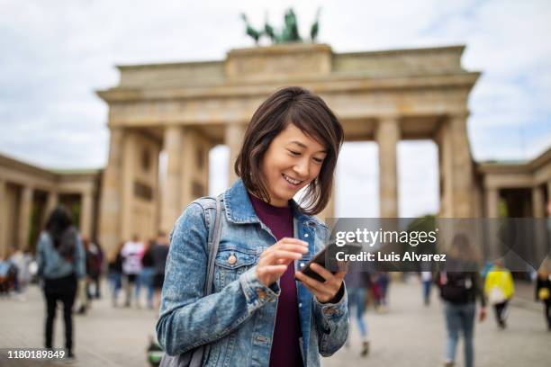 woman using smart phone against brandenburg gate - brandenburger tor 個照片及圖片檔