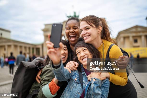 cheerful friends taking selfie against brandenburg gate - berlin people ストックフォトと画像