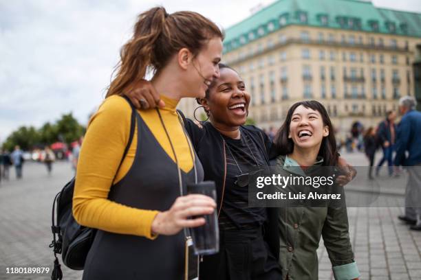 multi-ethnic friends walking in city during vacation - mitte stock pictures, royalty-free photos & images