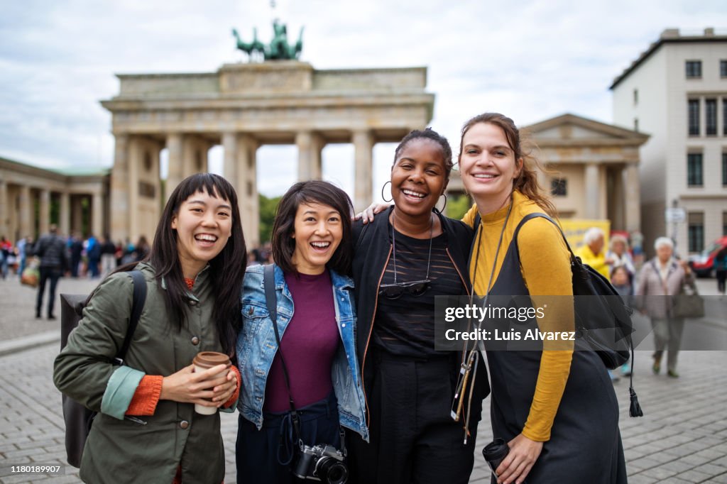 Cheerful female friends against Brandenburg Gate