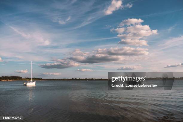 sailboat in the distance on a beautiful sunny day - vannes stock-fotos und bilder