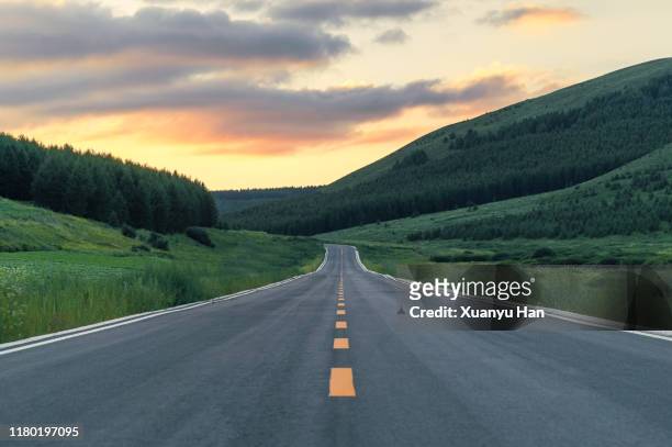 empty country road at dusk - wonderlust stock-fotos und bilder