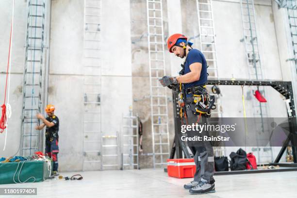 technicien d'accès de corde faisant la préparation - rope high rescue photos et images de collection