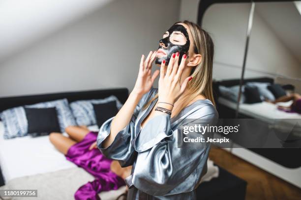 young woman applied facial mask - silk robe stock pictures, royalty-free photos & images