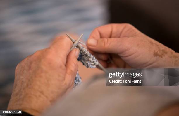 pov of an elderly lady knitting a grandchilds first jumper - lentigo stockfoto's en -beelden