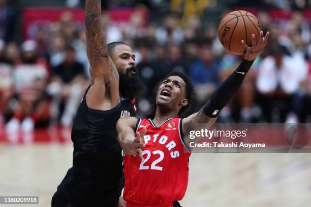 Patrick McCaw of Toronto Raptors lays the ball up against Tyson Chandler of Houston Rockets during the preseason match between Toronto Raptors and...