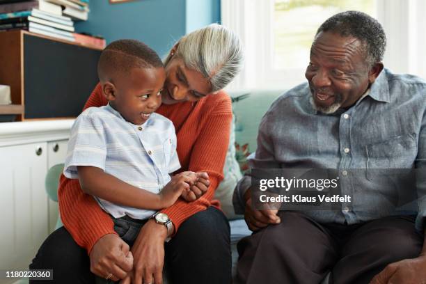 happy man talking with cute boy standing at home - introvert stock pictures, royalty-free photos & images